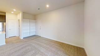 A large empty room with a carpeted floor and white walls. at Bridge at Speyside Apartments, Austin
