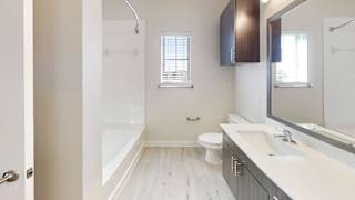 A white bathroom with a toilet, sink, and bathtub at Bridge at Speyside Apartments, Austin, 78754