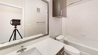 a bathroom with a mirror and a camera on a tripod at Bridge at Speyside Apartments, Austin, Texas