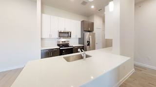 a kitchen with a white counter top and a sink at Bridge at Speyside Apartments, Texas