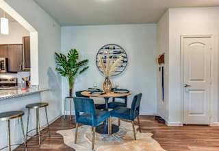 Dining area with round table and blue velvet chairs at High Point Preserve Apartments, Texas, 78724