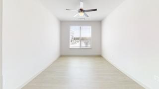 A room with a ceiling fan and a window. at ThreeTwenty at the Vybe Apartments, Kyle