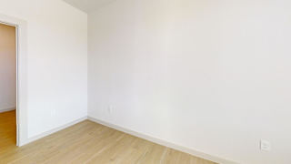 A room with a wooden floor and white walls. at ThreeTwenty at the Vybe Apartments, Texas