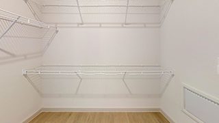 Empty white shelving unit in a room with wooden flooring. at ThreeTwenty at the Vybe Apartments, Kyle, 78640