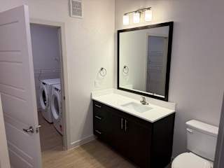 A bathroom with a white sink and a mirror above it.