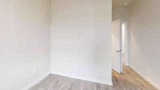 Empty corner room with light gray flooring at Bridge at Windsor Park Apartments, Austin, TX
