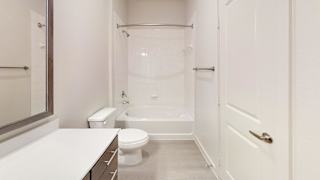 Bathroom with white tub and framed mirror at Cantarra Apartments, Manor, 78653
