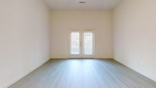 Empty room with double french doors and woodstyle flooring at Cantarra Apartments, Manor, TX