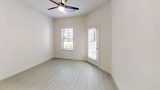 Empty room with door window and ceiling fan at Cantarra Apartments, Manor, Texas