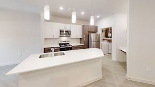 Modern kitchen with twotone cabinetry and island sink at Cantarra Apartments, Texas