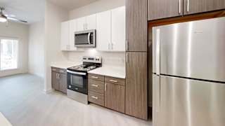 Kitchen with stainless steel appliances and two tone cabinets at Cantarra Apartments, Texas, 78653