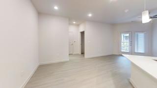 Spacious living room with recessed lighting and patio access at Cantarra Apartments, Manor, TX