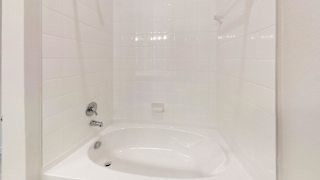 White tiled bathtub with chrome fixtures at Cantarra Apartments, Manor
