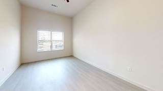 Empty room with vaulted ceiling and window blinds at Cantarra Apartments, Texas