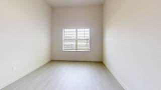 Empty room with window and laminate flooring at Cantarra Apartments, Manor, TX