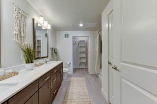 Master bathroom with dual vanity and walk-in closet 1 at Cantarra Apartments, Manor, TX