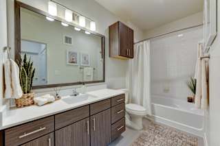 Bathroom with white countertop and wood grain vanity 1 at Cantarra Apartments, Manor