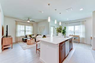 Open concept living and kitchen with island seating 1 at Cantarra Apartments, Manor, Texas