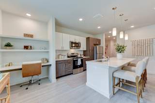 Open kitchen with work nook and island seating 1 at Cantarra Apartments, Manor, TX 78653