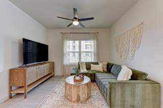 Living room with green sofa and modern décor 1 at Cantarra Apartments, Manor, 78653