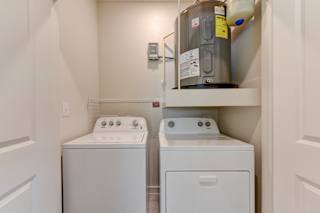 Laundry room with washer dryer and water heater 3 at Cantarra Apartments, Manor, Texas