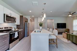 Open concept kitchen with white island and modern finishes 1 at Cantarra Apartments, Texas