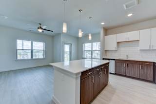 Open concept kitchen and living area with island at Cantarra Apartments, Manor, Texas