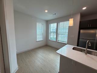 A kitchen with a sink and a window with blinds.