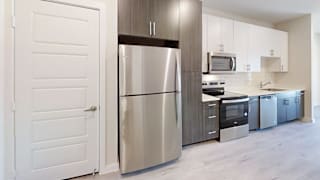 a kitchen with stainless steel appliances and white cabinets at Bridge at Speyside Apartments, Texas