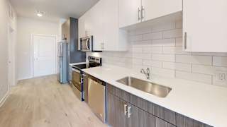 a renovated kitchen with stainless steel appliances and white cabinets at Bridge at Speyside Apartments, Austin, TX, 78754