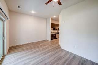 a bedroom with a ceiling fan and a kitchen in the background at Avery Ranch, Austin Texas