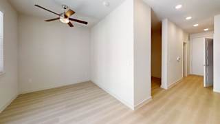 A room with a ceiling fan and lighting fixtures.