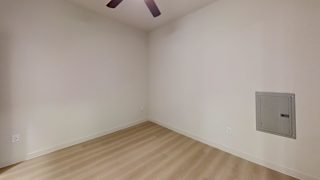 A room with a ceiling fan and a light switch on the wall.