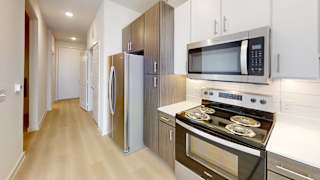 A kitchen with a stove, microwave, and refrigerator.