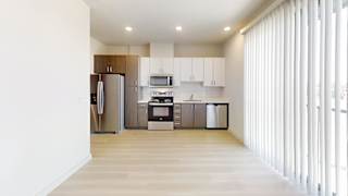 A kitchen with white cabinets and a refrigerator.