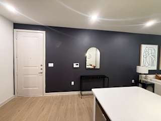 A room with a white door and a black table.