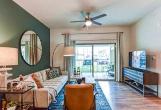 Living room with accent wall and sliding patio door 1 at High Point Preserve Apartments, Austin