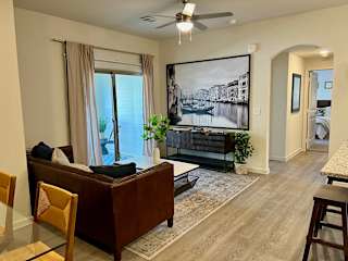 Living room with brown leather sofa and tv console at High Point Preserve Apartments, Austin, TX 78724