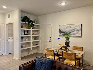 Dining space with natural wood furniture and wall art at High Point Preserve Apartments, Austin, Texas