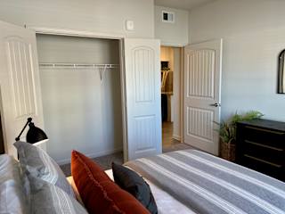 Bedroom with open closet and adjacent hallway at High Point Preserve Apartments, Texas