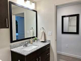 Bathroom vanity with mirror and towel ring 1 at High Point Preserve Apartments, Austin, TX 78724