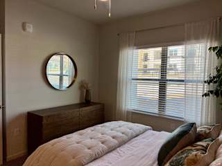 Bedroom with round mirror and wood dresser 1 at High Point Preserve Apartments, Austin, 78724