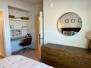 Bedroom with built in desk nook and wood dresser at High Point Preserve Apartments, Austin, Texas