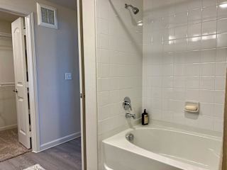 White tile tub shower with builtin soap ledge 1 at High Point Preserve Apartments, Texas