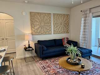 Living room with navy sectional sofa and geometric wall art 2 at High Point Preserve Apartments, Austin, Texas