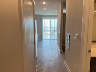 Hallway view with balcony access and natural light at Bridge at Windsor Park Apartments, Austin, TX