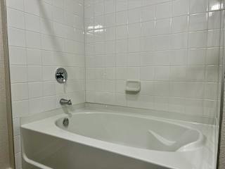 Alcove bathtub with subway tile surround and chrome faucet at Bridge at Windsor Park Apartments, Austin, Texas