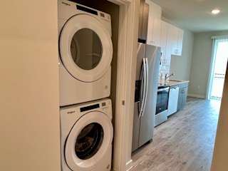 Stacked washer and dryer in closet nook at Bridge at Windsor Park Apartments, Austin, TX 78723