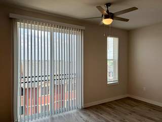 Bedroom with sliding glass door and vertical blinds at Bridge at Windsor Park Apartments, Texas, 78723