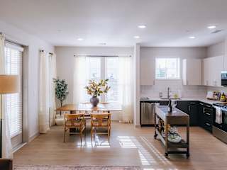 A kitchen with a dining table and chairs in the middle of the room.